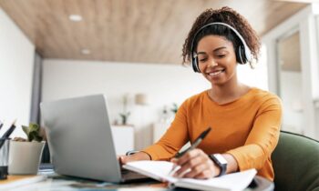 A woman working from a table in her home office as a legal transcriptionist.