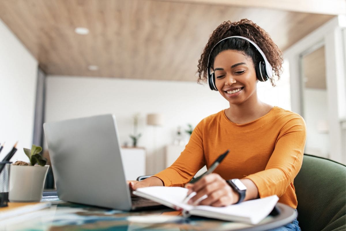 A woman working from a table in her home office as a legal transcriptionist.