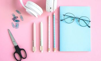 Still life of freelancer's desk with headphones, notepad, and other home office accessories.