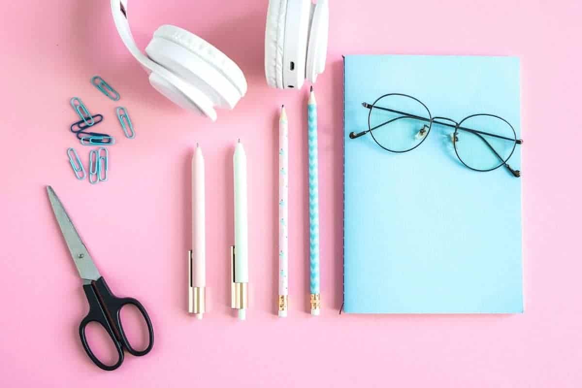 Still life of freelancer's desk with headphones, notepad, and other home office accessories.