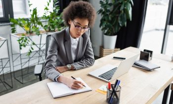 A lawyer working from home at her desk with houseplants in the background.