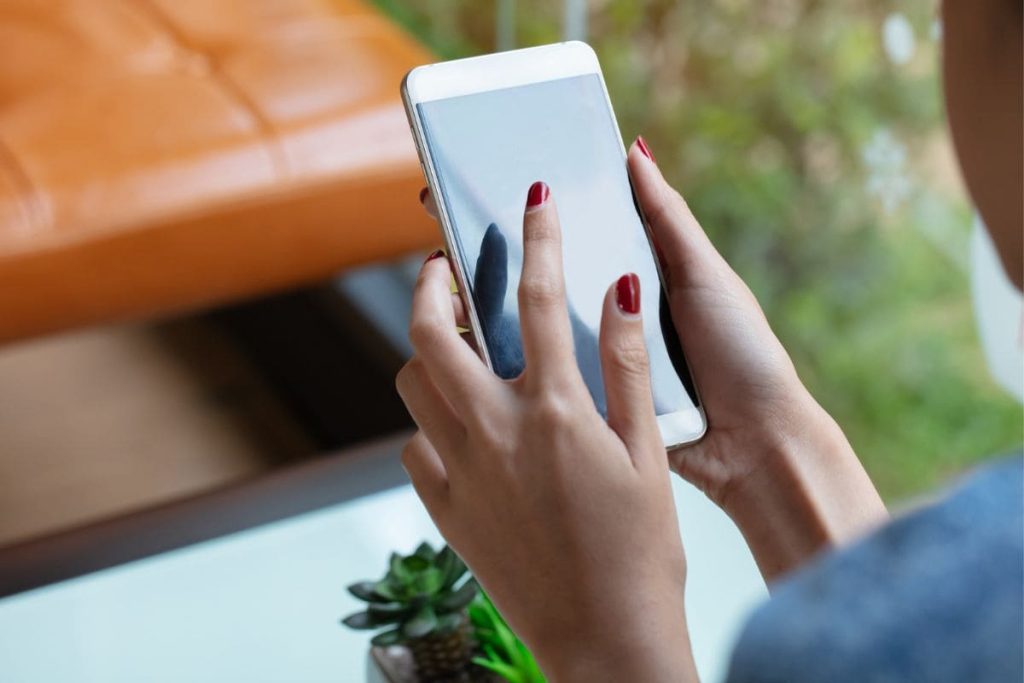 Closeup of a woman using a phone to text for money.