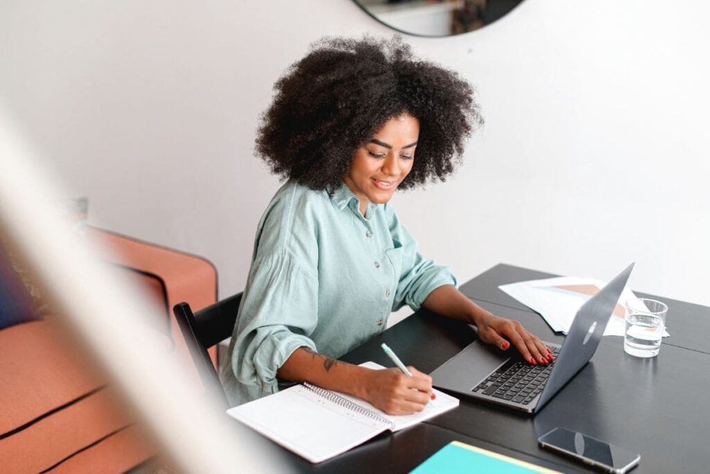 A happy woman working on a computer from her home office.