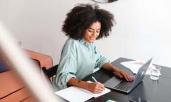 A happy woman working on a computer from her home office.