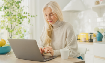 A female retiree earning extra money from home on laptop