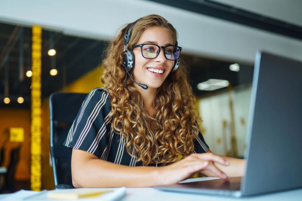 An American Express work from home employee, using a laptop and headset from her home office.