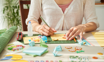 Woman sitting at a table creating one-of-kind greeting cards