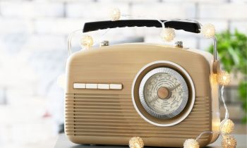 A vintage radio decorated with string lights sitting on a table.