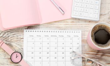 A woman's home office desk, with a calendar and calculator.