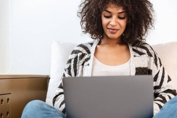 Woman writing on laptop at home.