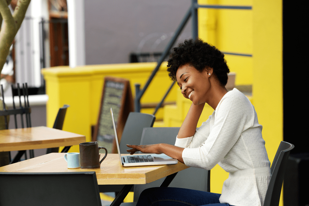 Young woman working outside at a cafe on her laptop