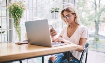 A woman working from home at a kitchen table.