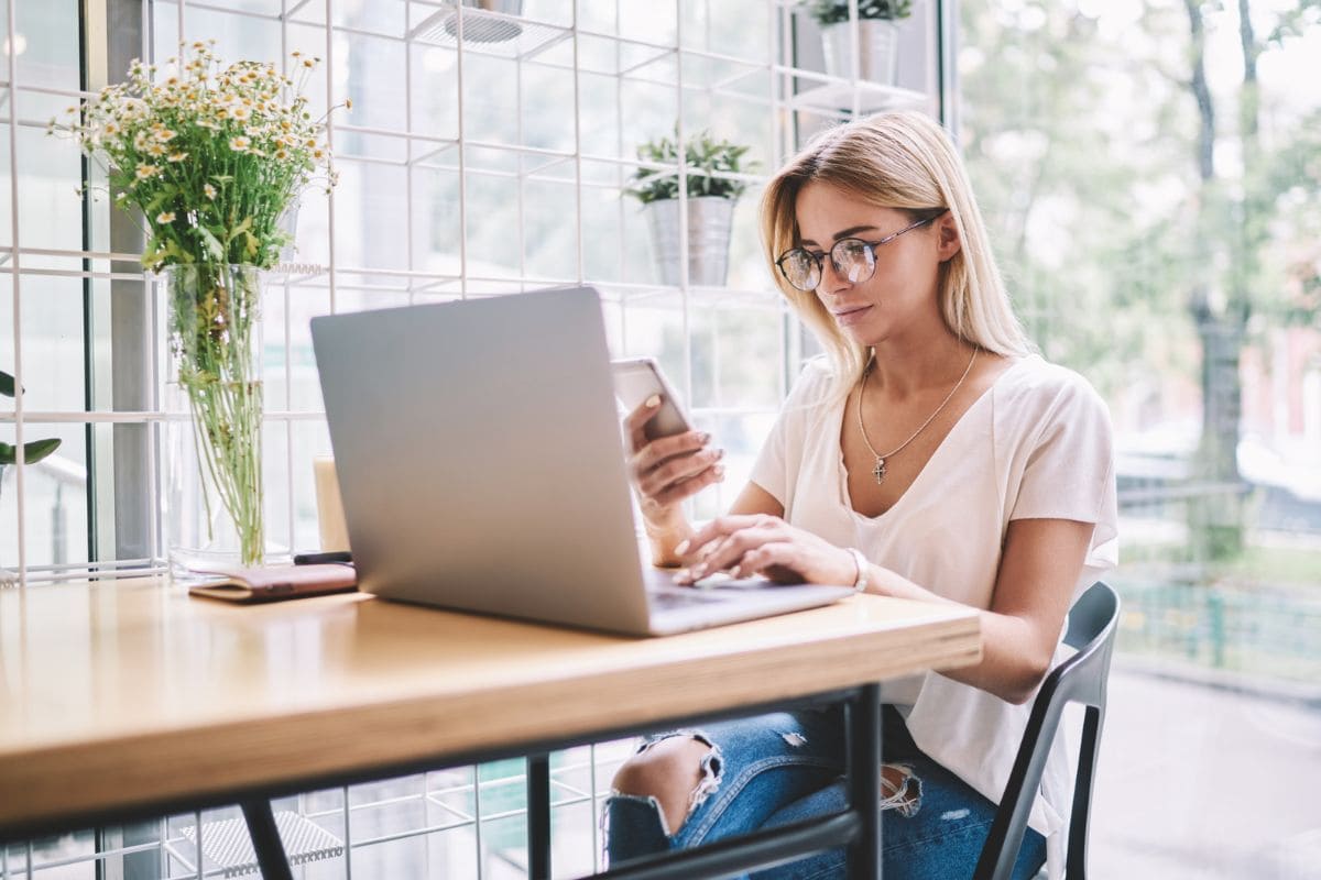 A woman working from home at a kitchen table.