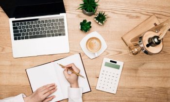 Woman at home, using a calculator to determine budget for unpaid bills