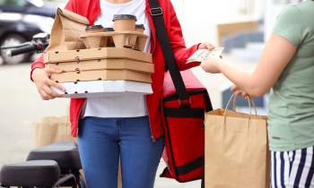 Woman delivering coffee and food to customer for money