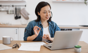 woman sitting at her desk in a meeting - blog post work at home jobs with Google