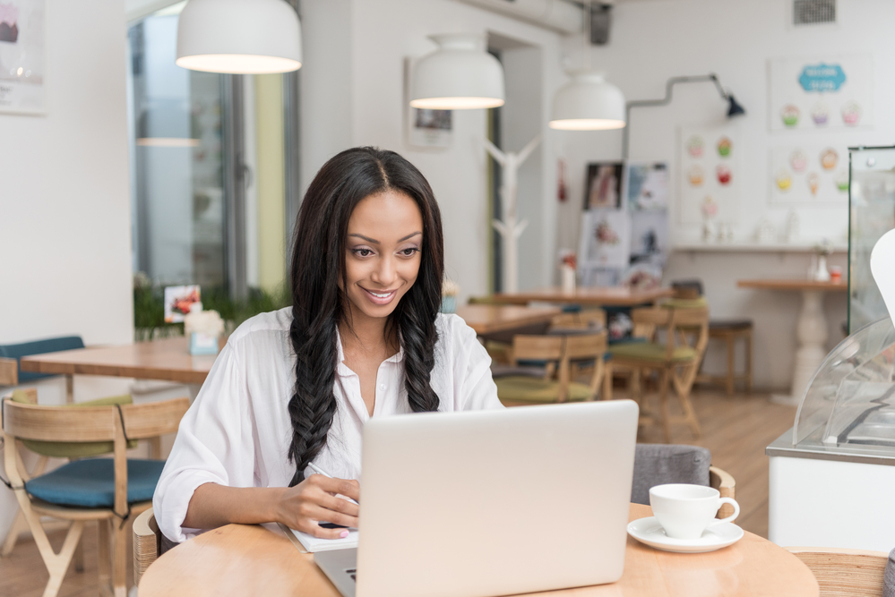 woman working in a cafe testing websites for cash