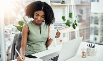 Young black woman writing in a notebook taking a free online course