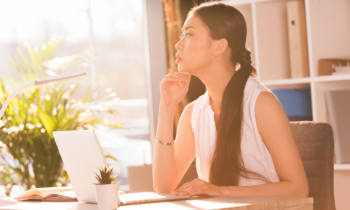 Young woman looking at her laptop wondering if she's applying for a work at home scam