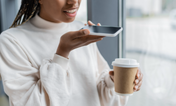 Young woman making money recording her voice with smartphone