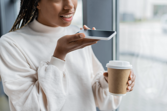 Young woman making money recording her voice with smartphone