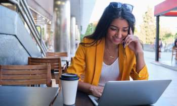 Young woman working at a cafe on her laptop for her flexible work from home jobs