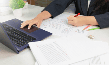 woman working on laptop and proofreading documents from home